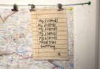 A list reading “my friends, my friends, my friends, my friends, my friends, road trips, swimming” signed R, clipped on a map.