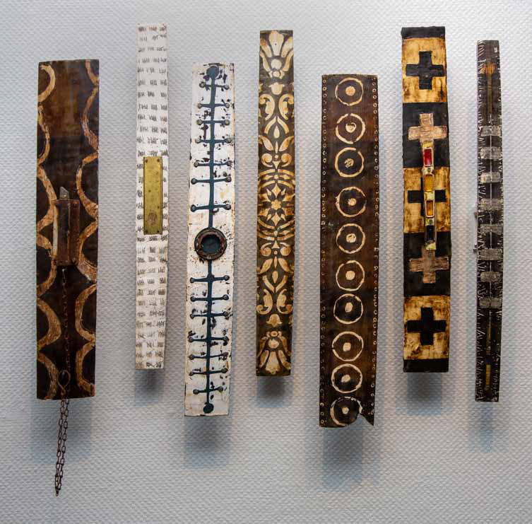 7 totem like wooden elongated rectangular pieces - laid out in a row