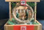 A set made of wood, foliage, twine, with a small fox in the center.
