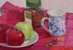 Still life painting of apples on a plate, china mug, glass jar and spoon on a red table cloth