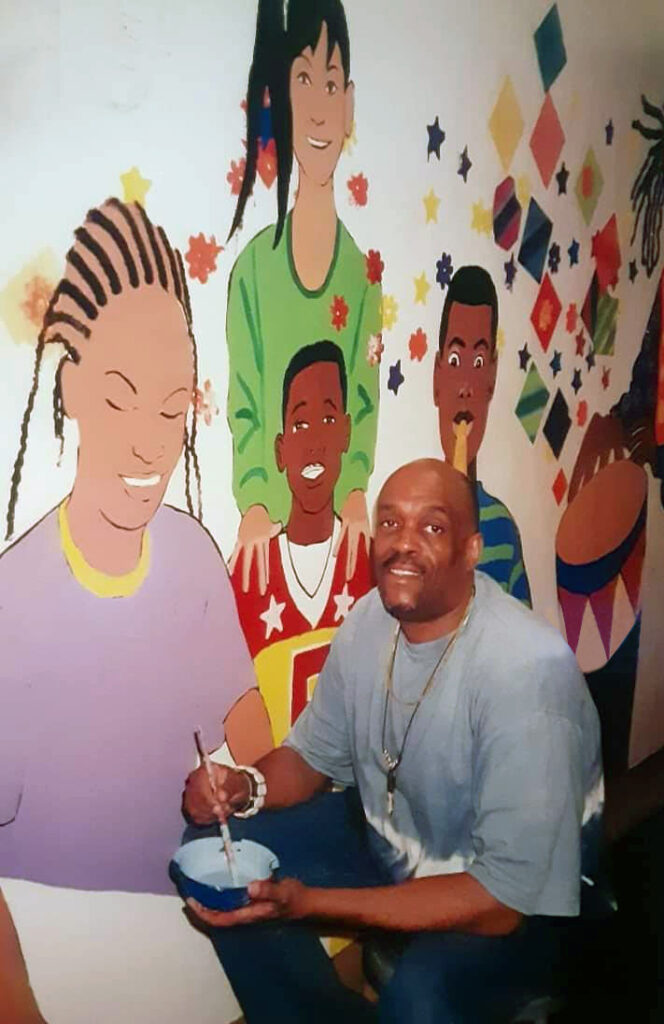 Elton Tucker painting a mural at the Joseph P. Kennedy Jr. Community Center in Harlem.