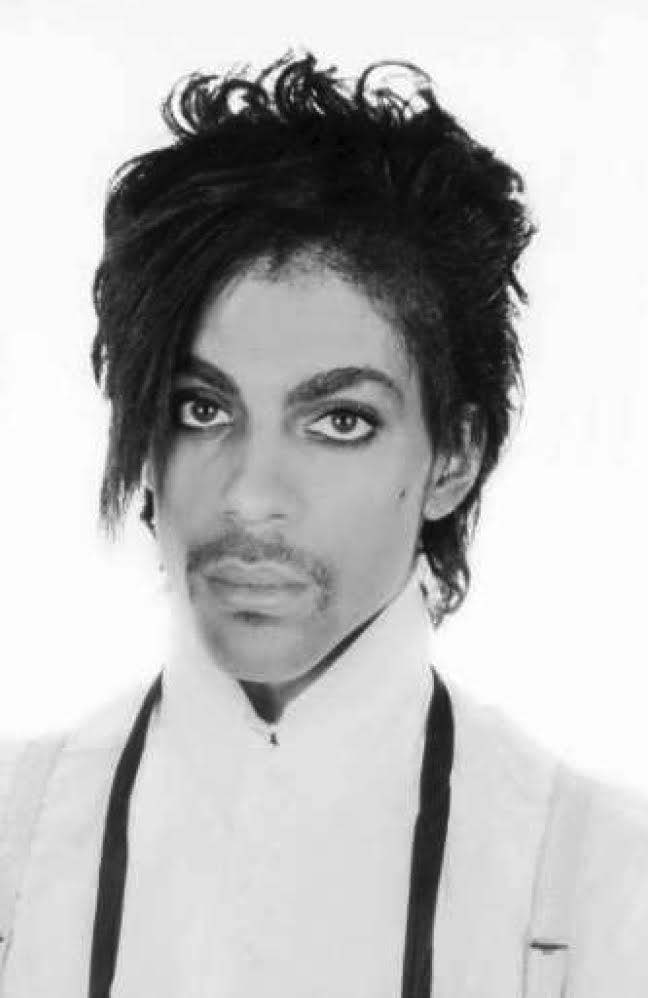 A black and white portrait photograph of Prince taken in 1981 by Lynn Goldsmith.
